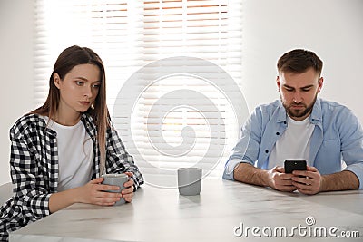 Man preferring smartphone over his girlfriend at home. Relationship problems Stock Photo