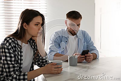 Man preferring smartphone over his girlfriend at home. Relationship problems Stock Photo