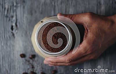 Young man prepares coffee in a beige moka pot Stock Photo