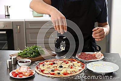 Young man preparing tasty pizza at table Stock Photo