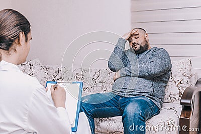 Young man at the psychotherapist visit, talking about his problems with emotions, mental health concept Stock Photo