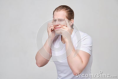 A young man pulls his eyes. The concept myopia, farsightedness Stock Photo