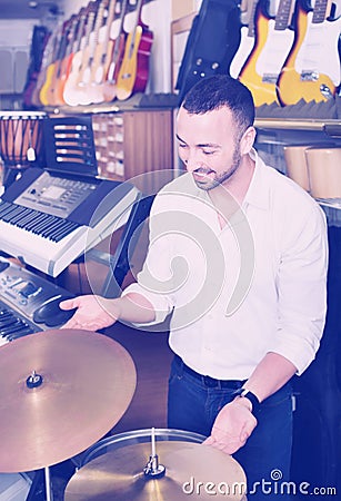 Young man purchasing professional drum set in store Stock Photo