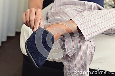 Young man putting on his slippers Stock Photo