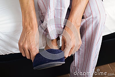 Young man putting on his slippers Stock Photo
