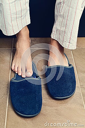 Young man putting on or off his slippers Stock Photo