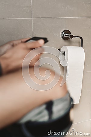 Young man reading in the toilet Stock Photo