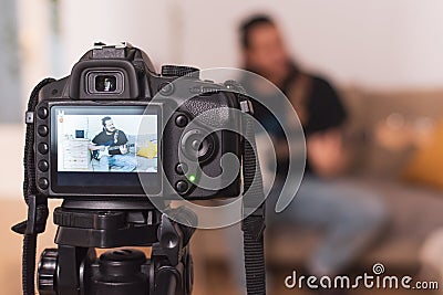 Young man recording an online guitar lesson video tutorial at home Stock Photo