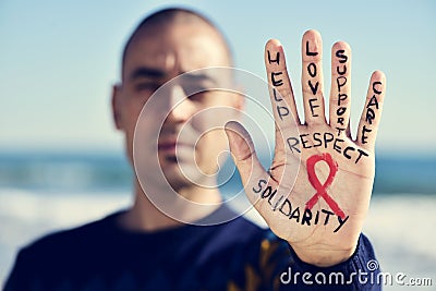 Young man with a red ribbon for the fight against AIDS in his ha Editorial Stock Photo