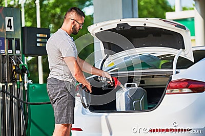 Young man refueling canister with fuel. Stock Photo