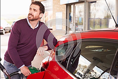 Young man refuelling a car at a petrol station Stock Photo