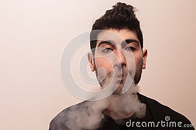 Young man releases a lot of smoke. Stock Photo