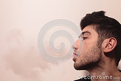 Young man releases a lot of smoke. Stock Photo