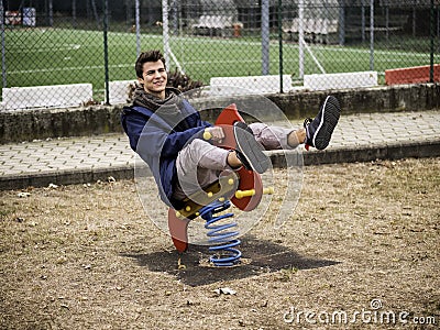 Young man reliving his childhood in a playground Stock Photo