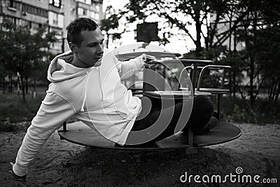 Young Man Reliving His Childhood Plying In A Children`s Playground Stock Photo