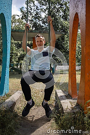 Young Man Reliving His Childhood Plying In A Children`s Playground Stock Photo