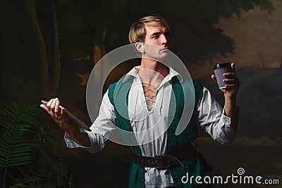 Young man in Renaissance style uses gadgets. Stock Photo