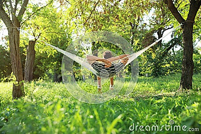Young man resting in comfortable hammock at garden Stock Photo