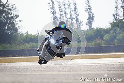 Young man riding big bike motorcycle against sharp curve of asphalt high ways road with rural lake scene use for male adventure ac Stock Photo