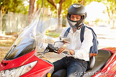 Young Man Riding Motor Scooter To Work Stock Photo