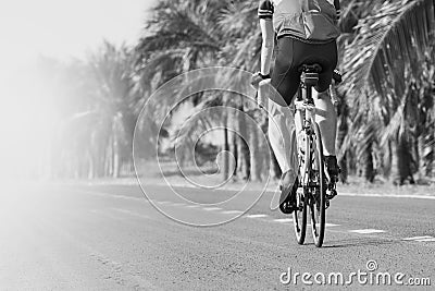 Young man riding road biking bycycle on asphalt track in black a Stock Photo