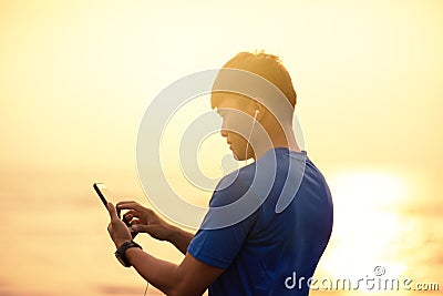 Man running on beach and checking Heart Rate Monitor On smart phone Stock Photo