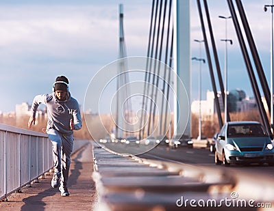A young man running on the bridge along a river. Stock Photo