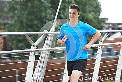 Young Man Running In Urban Setting Listening To Music Stock Photo