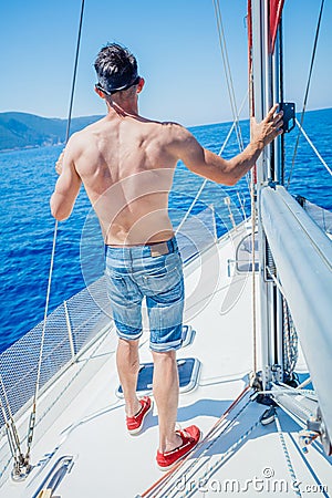 Young man sailing yacht Stock Photo