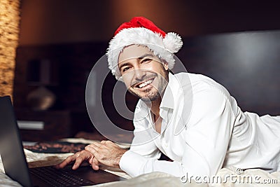 Young man with santa hat online shopping Stock Photo