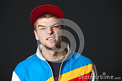 Young man saw something disgusting - on dark background. Stock Photo