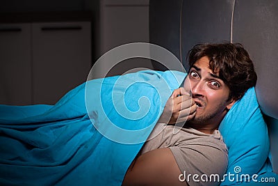 The young man scared in his bed having nightmares Stock Photo