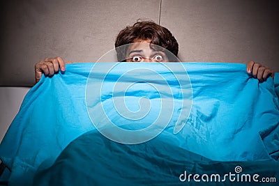 The young man scared in his bed having nightmares Stock Photo
