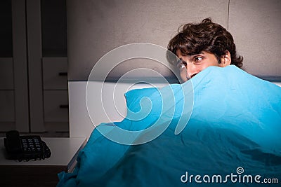 The young man scared in his bed having nightmares Stock Photo