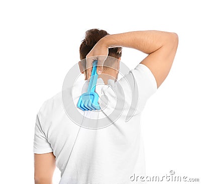 Young man scratching back with toy rake on white background. Stock Photo