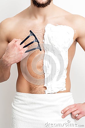 Young man shaving his chest Stock Photo
