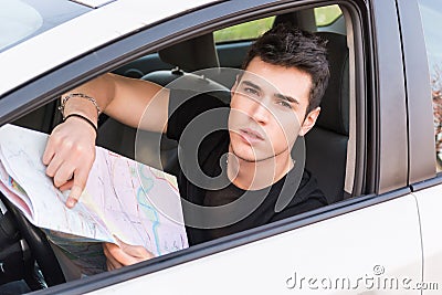 Young Man showing map inside of a car Stock Photo