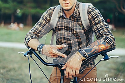 Young Man Shows A Sign Of Peace Or Victory Sitting On A Bicycle On Green Summer Meadow Stock Photo