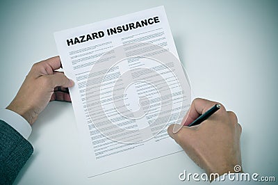 A young man signing a hazard insurance policy Stock Photo