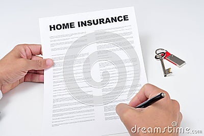 A young man signing a home insurance policy Stock Photo