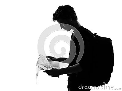 Young man silhouette backpacker reading map Stock Photo