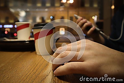 Young man sits in a cafe and reads messages in the phone Stock Photo