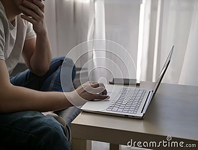 Man sitting at a laptop at home by the window, close-up Stock Photo