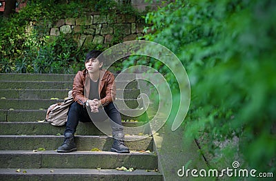 Young man sitting, loneliness, among the nature Stock Photo