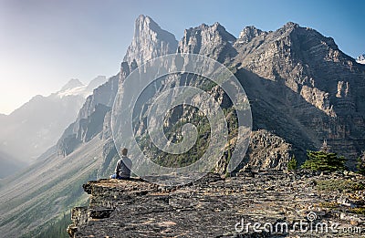 Young man sitting on top of the high peak Editorial Stock Photo