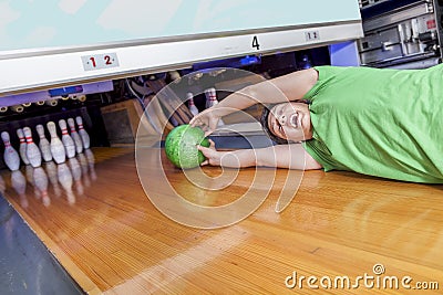 Young man sliding down a bowling alley Stock Photo