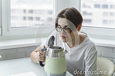 A young man smells unpleasant from the electric kettle Stock Photo