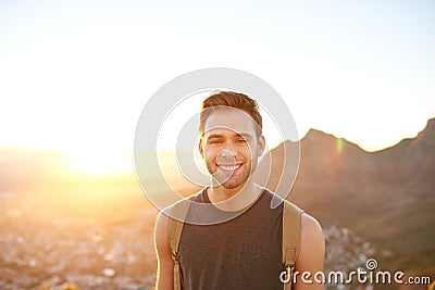 Young man smiling while on an early morning nature hike Stock Photo