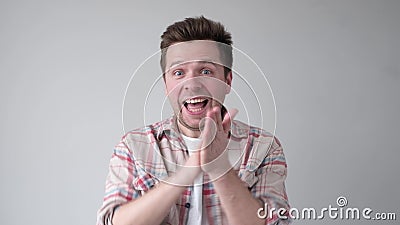 Young man smiling with glee as he rubs his hands together Stock Photo