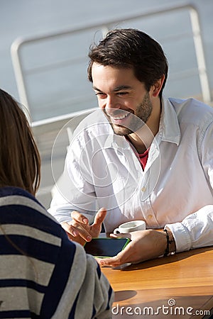 Young man smiling and showing woman mobile phone Stock Photo